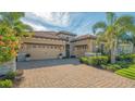 Charming single-story home with a three-car garage, tile roof, and colorful front yard plants at 7213 Whittlebury Trl, Lakewood Ranch, FL 34202