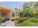 Inviting front entrance with a glass paneled door and beautiful landscaping at 7317 Emma Rd, Bradenton, FL 34209