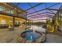 Beautiful pool and hot tub featuring an outdoor kitchen and screened-in enclosure at 7327 Greystone St, Lakewood Ranch, FL 34202
