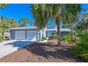Inviting home featuring a two-car garage, neutral siding, well-kept landscaping, and beautiful palm trees at 7816 15Th Nw Ave, Bradenton, FL 34209