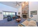 Cozy living room features a soaring ceiling, stone fireplace, plush seating, and sliding doors to the lanai at 7816 15Th Nw Ave, Bradenton, FL 34209