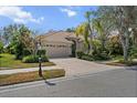 Charming single-story home with a paved driveway, tile roof, two-car garage, and professionally landscaped yard at 866 Placid Lake Dr, Osprey, FL 34229