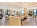 Open-concept living room with breakfast bar and expansive water views from large windows at 8779 Midnight Pass Rd # 406H, Sarasota, FL 34242