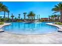 Resort-style pool with palm trees, fountains, and a shaded pergola provides a luxurious outdoor experience at 9743 Pembrooke Pines Dr, Sun City Center, FL 33573