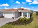 Beautiful single-story home featuring a tile roof, paved driveway, and colorful landscaping at 10240 Beach Dune Dr, Englewood, FL 34223