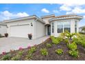 Beautiful one-story home boasts a paver driveway, colorful flowers, and lush, tropical landscaping at 10240 Beach Dune Dr, Englewood, FL 34223