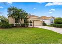 Inviting single-Gathering home featuring a manicured lawn, mature landscaping, and attached garage at 12710 Rockrose Gln, Lakewood Ranch, FL 34202