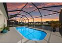 Relaxing screened-in pool overlooking a tranquil waterfront view, creating a private outdoor oasis at sunset at 12726 Rainwashed Loop, Parrish, FL 34219