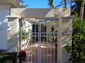 Charming entry gate leads to a private brick-paved courtyard with lush greenery at 1354 Tearose Pl, Sarasota, FL 34239