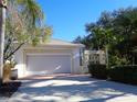 View of the two-car garage on a single-story home with paver driveway at 1354 Tearose Pl, Sarasota, FL 34239