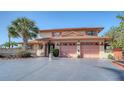 Inviting two-story home with a spacious driveway and lush greenery, perfect for Gathering living at 1444 Ridgewood Ln, Sarasota, FL 34231