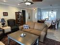 Comfortable living room featuring tile floors, neutral tones, and a view into the dining room at 1805 Springwood Dr, Sarasota, FL 34232