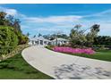 The circular driveway leads to this home with manicured landscaping and metal roof at 1909 Field Rd, Sarasota, FL 34231