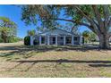 Spacious backyard featuring a screened-in lanai, lush lawn, and mature shade trees at 2402 Scenic Dr, Venice, FL 34293