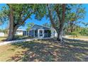 Backyard view of the home with a screened-in porch, mature shade trees, and a fenced yard at 2402 Scenic Dr, Venice, FL 34293