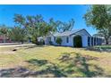 A charming single-story house with a spacious yard, mature trees, and a screened-in lanai at 2402 Scenic Dr, Venice, FL 34293