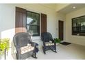 Inviting front porch with seating area for relaxing and enjoying the outdoors at 253 Tracino Ter, Nokomis, FL 34275