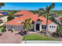 Beautiful single-Gathering home featuring lush landscaping, a brick driveway, and a classic tile roof at 261 Portofino Dr, North Venice, FL 34275