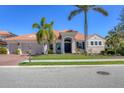 Charming single-Gathering home featuring lush landscaping, a brick driveway, and a classic tile roof at 261 Portofino Dr, North Venice, FL 34275
