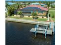 A waterfront house featuring solar panels, a screened lanai, and boat dock with a boat lift at 3572 Peace River Dr, Punta Gorda, FL 33983