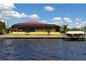 Waterfront home with a screened lanai, a red metal roof, and direct access to the water and boat dock at 3572 Peace River Dr, Punta Gorda, FL 33983