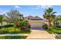 Charming single-story home featuring a two-car garage and vibrant landscaping at 3838 Manorwood Loop, Parrish, FL 34219