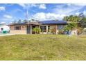 Charming single-story home featuring solar panels, a well-manicured lawn, and a decorative cannon on the front lawn at 392 Yeager St, Port Charlotte, FL 33954