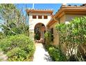 Inviting home entrance with arched doorway, lush greenery, and a well-maintained walkway at 4141 Entrada Ct, Sarasota, FL 34238