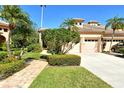 Beautiful home with a well-manicured lawn, lush landscaping, and a two-car garage on a sunny day at 4141 Entrada Ct, Sarasota, FL 34238