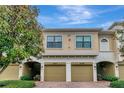 Beige condo building with garages and green foliage in the front at 4210 Overture Cir, Bradenton, FL 34209
