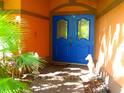 Inviting home entrance featuring a double blue door, unique design elements, and a well-manicured landscape at 4535 San Siro Dr, Sarasota, FL 34235
