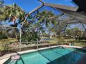 Enclosed pool area with a view of the yard with tropical landscaping and a scenic pond at 4535 San Siro Dr, Sarasota, FL 34235