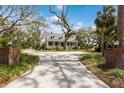 Inviting two-story home featuring a classic porch with rocking chairs and mature trees at 4871 Hoyer Dr, Sarasota, FL 34241