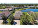 Aerial view of a home next to a tranquil pond within a lush residential community at 5015 98Th E Ave, Parrish, FL 34219
