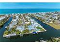 An aerial view of waterfront homes with boat docks and pools along canals in a coastal community at 511 Loquat Dr, Anna Maria, FL 34216