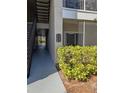 Exterior walkway of a condo building with stairs, a unit listing, and exterior trees at 5168 Northridge Rd # 102, Sarasota, FL 34238