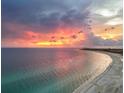 A scenic view of the coastline and ocean with a colorful sunset sky at 6512 Midnight Pass Rd # 504, Sarasota, FL 34242