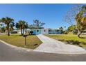 Quaint single-story home with light blue and white exterior paint, complemented by lush palm trees at 6520 Clemson St, Bradenton, FL 34207