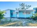 Light blue single-story home featuring a covered front porch with white support columns and a dark wood-stained deck at 6520 Clemson St, Bradenton, FL 34207