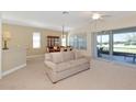 Spacious living room featuring neutral colors, fan, and lots of natural light from the backyard patio at 708 Foggy Morn Ln, Bradenton, FL 34212