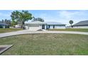 Beautiful single-story home featuring a spacious lawn, light blue exterior and a metal roof at 7523 S Leewynn Dr, Sarasota, FL 34240