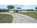 Charming single-story home with a well-manicured lawn and a concrete driveway at 7523 S Leewynn Dr, Sarasota, FL 34240