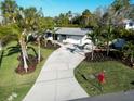 Beautifully landscaped property with a long driveway leading to the charming home at 7701 Palm Dr, Holmes Beach, FL 34217