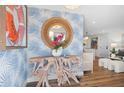 Charming foyer with a driftwood console, coastal-themed wallpaper, and a round rattan mirror at 7701 Palm Dr, Holmes Beach, FL 34217