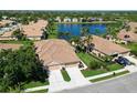 Scenic aerial view of a tan home with a large lake in the background at 8211 Summer Greens Ter, Bradenton, FL 34212