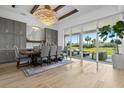 Bright dining area with a grand chandelier, large windows, and outdoor patio access at 8227 Nevis Run, Bradenton, FL 34202