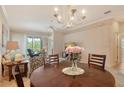 Cozy dining area with a round table, chandelier, and a view into the living space at 9411 Forest Hills Cir, Sarasota, FL 34238