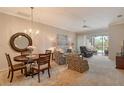 Open living area featuring a chandelier, comfortable seating, and seamless access to the lanai at 9411 Forest Hills Cir, Sarasota, FL 34238
