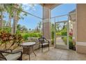 Inviting screened-in patio with tile flooring, wicker furniture and pleasant outdoor views at 9411 Forest Hills Cir, Sarasota, FL 34238