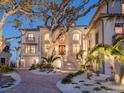 Stately home with brick driveway, elegant landscaping, and mature trees for privacy and curb appeal at 1216 N Casey Key Rd, Osprey, FL 34229